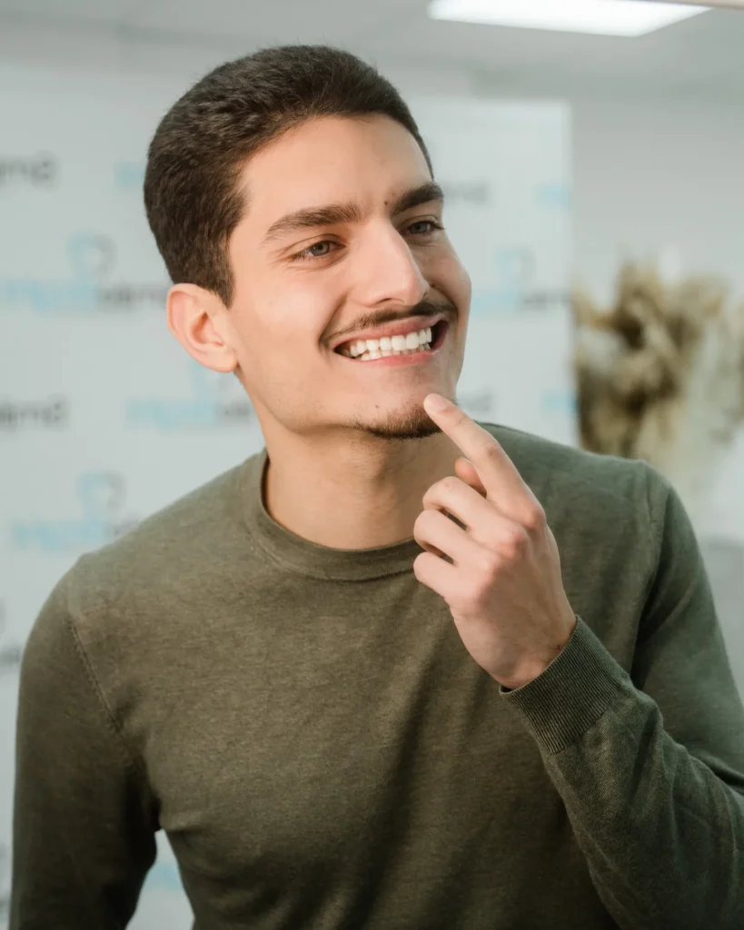 Junger Mann lächelt zufrieden nach einer professionellen Zahnaufhellung bei Smile Bright in Düsseldorf.