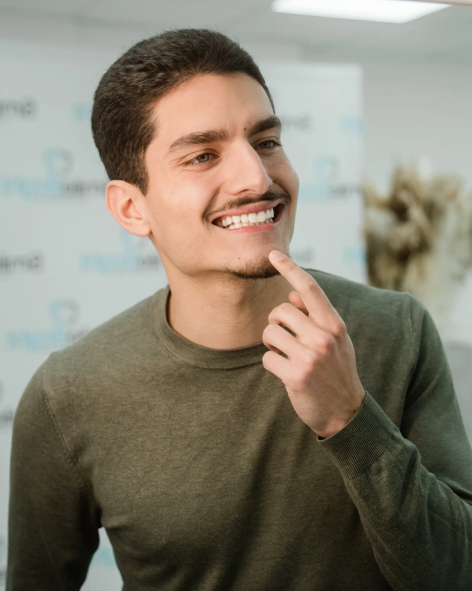 Junger Mann lächelt zufrieden nach einer professionellen Zahnaufhellung bei Smile Bright in Düsseldorf.